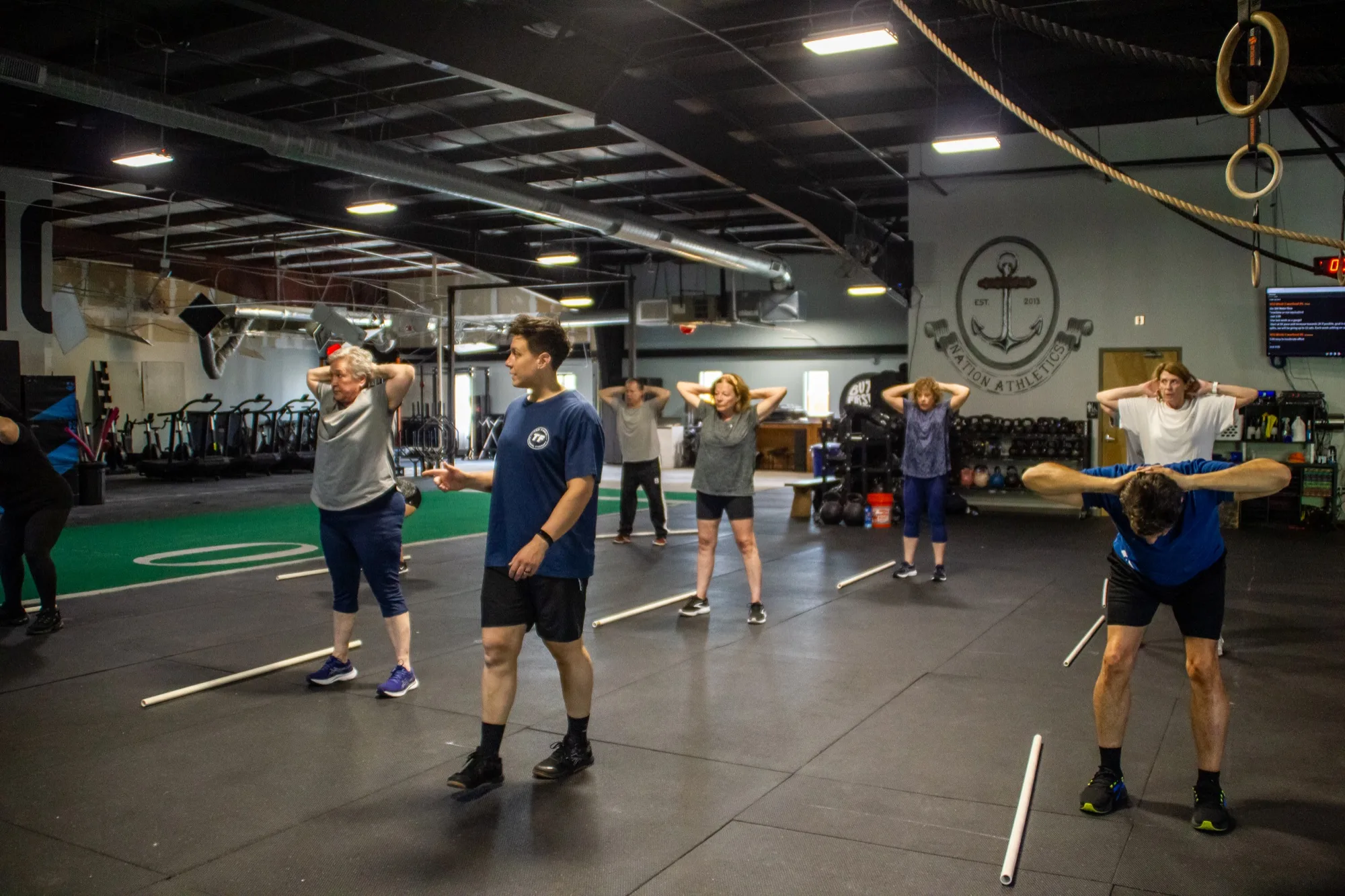 Older adults work through a guided mobility warmup during a PLUS class at Top Form Physical Therapy, Branford CT